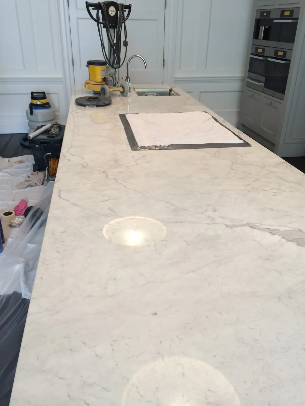 Carrara marble kitchen island before etch removal and polishing