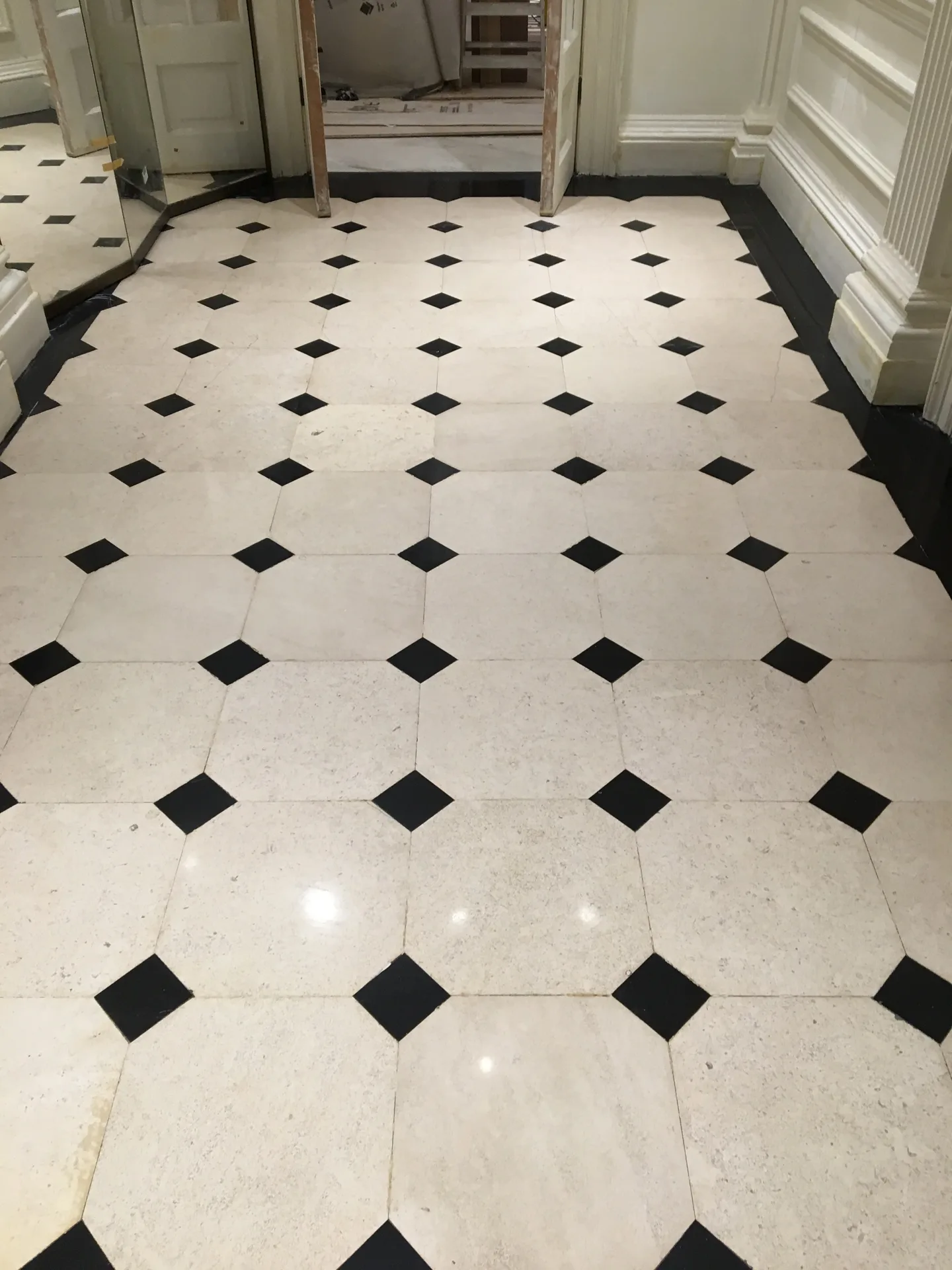 Cream marble hallway floor with black cabochons after full restoration
