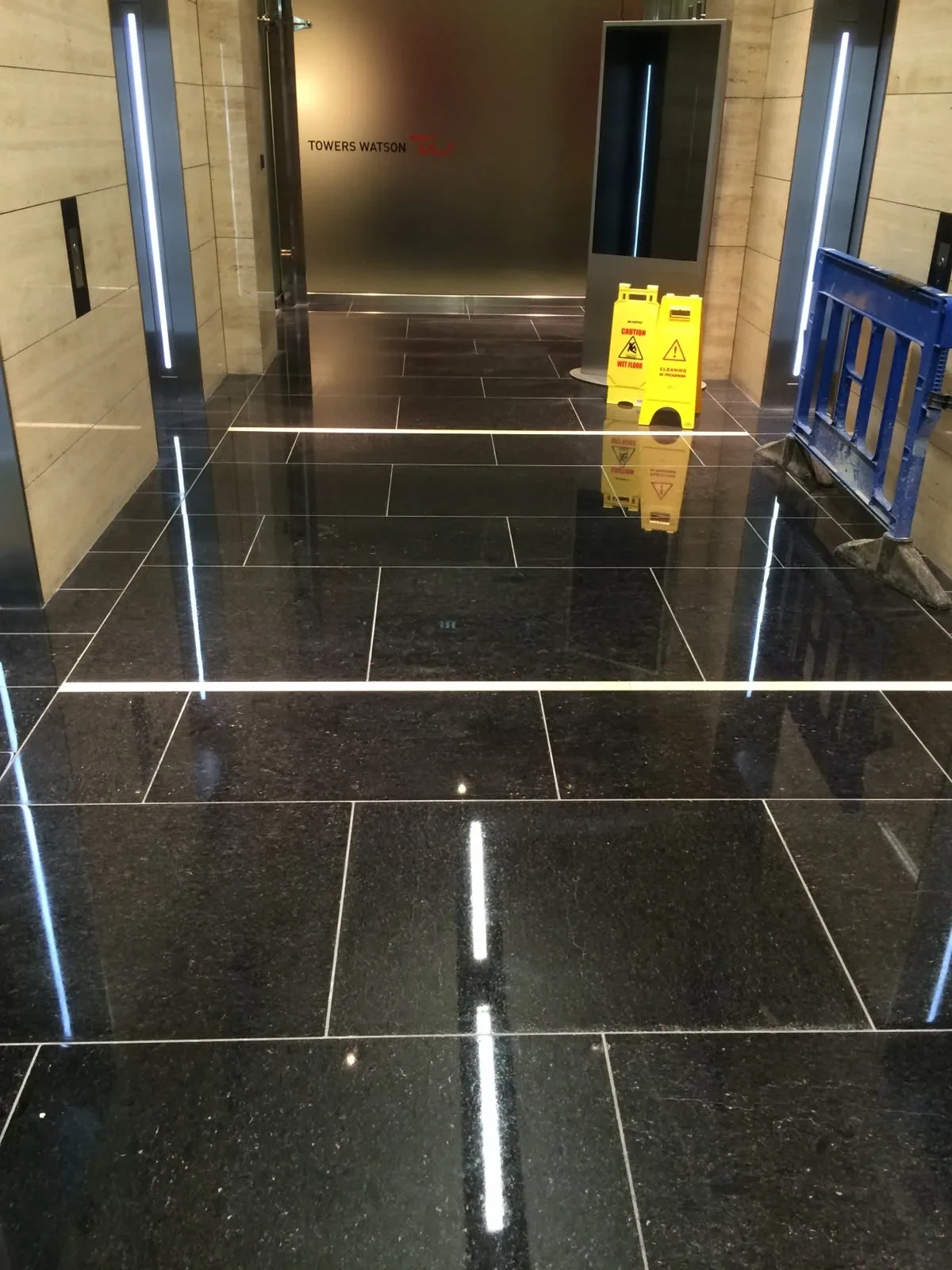 Black granite office lift lobby with a polished finish